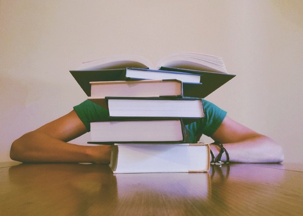 Person behind a stack of books