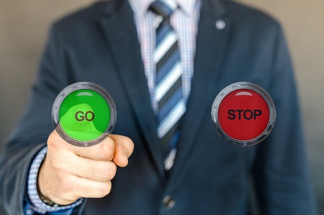 business, choice, solutionBusinessman in a suit pointing at two large buttons, one green labelled 'GO' and the other red labelled 'STOP,' symbolising decision-making and choosing a course of action